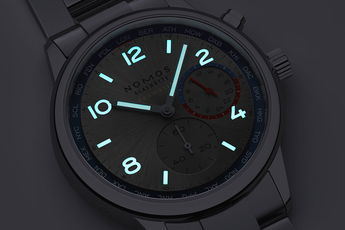 The Club Sport Neomatik Worldtimer dial at night.